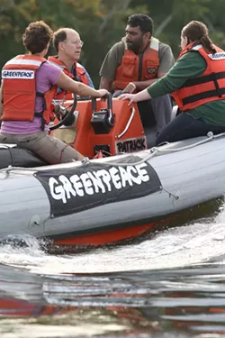 GREENPEACE - AN ACTIVE RIDE: Kumi Naidoo (second from right) tours Mountain Island reservoir with locals.