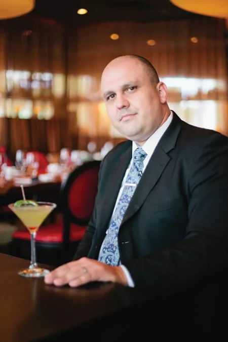 General Manager Aaron Ward with a signature cocktail - LOGAN CYRUS