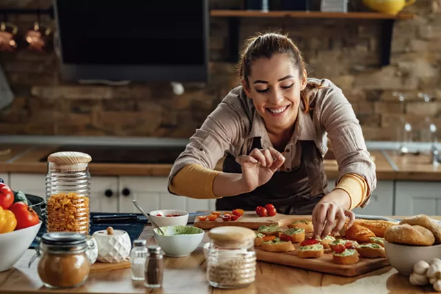 young-smiling-woman-making-bruschetta-with-healthy-ingredien.webp