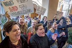 About 100 students yelled chants like “Margaret Spellings you can’t hide, we can see your greedy side,” down the hall from a Dec. 11 UNC Board of Governors meeting. (Photo by Grant Baldwin)