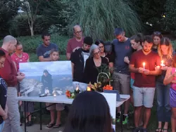 Harris' brother, Sam (right, red shirt) addressed the crowd before asking for a moment of silence. - RYAN PITKIN