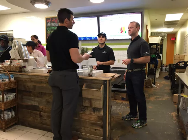 Josh Norris (right) chats with customer Brett Ezarsky at Green Brothers' Bank of America Plaza store