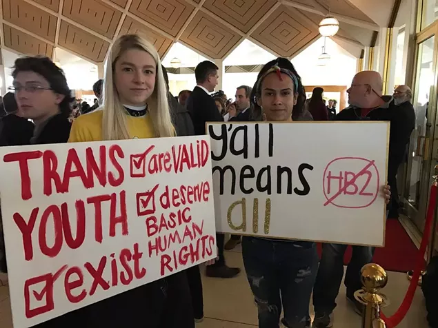 Hunter Schafer (left) and Miquel Rodrigues of Raleigh protest the North Carolina General Assembly during a special session on Wednesday, Dec. 21. (Photo by James Willamoor)