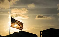 A school flag flies at half staff following the Feb. 18 slaying of 17 students at a Florida high school.