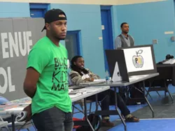 Jason Terrell (left) and Mario Javon Shaw (center) look on as a young student freestyles at a recent hip-hop event hosted by Profound Gentlemen. (Photo by Ryan Pitkin)